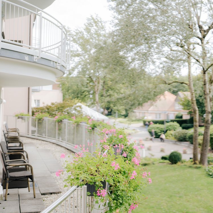 Außenbereich mit Bäumen und Terrasse im Golf & Sporthotel