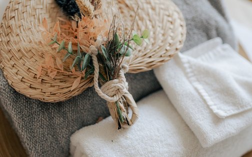 Wellnesshandtücher, Bademantel und Duftkerze im Spa-Bereich des Golf & Sporthotel Wiesensee