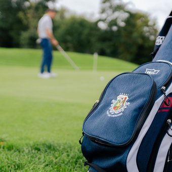 Golfspieler und Golftasche mit Logo des Golfclubs Wiesensee