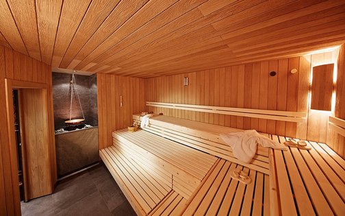 Sauna mit Holzverkleidung und stimmungsvoller Beleuchtung im Golf & Sporthotel Wiesensee