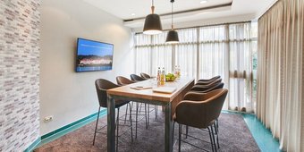 Heller Konferenzraum mit großem Tisch und TV-Bildschirm im Golf- & Sporthotel Wiesensee
