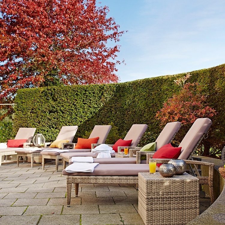 Entspannter Außenbereich mit Liegestühlen und Grünanlage am Spa des Golf & Sporthotel Wiesensee