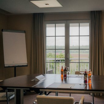 Moderner Tagungsraum mit Tischgruppen und TV-Bildschirm im Golfhotel Wiesensee