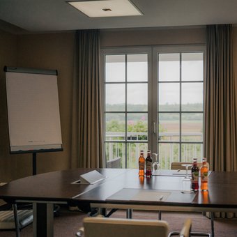 Moderner Tagungsraum mit Tischgruppen und TV-Bildschirm im Golfhotel Wiesensee