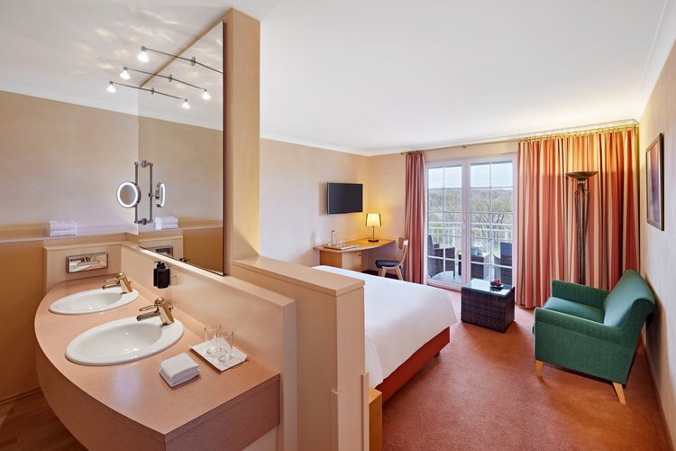 Zimmerübersicht mit Balkon, Sofa und hellem Design